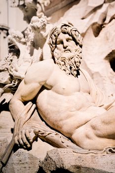 Magnificent marble sculpture depicting a river god in sunlight at a famous Lazio, Italy fountain.