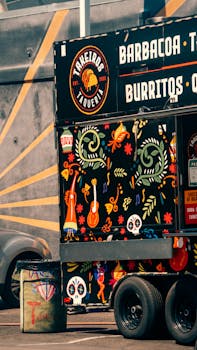 Colorful Mexican food truck with vibrant artwork and bold textures in a sunny urban setting.