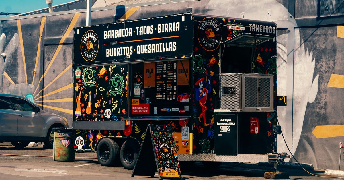 Vibrant Mexican food truck offering tacos and burritos in a lively urban environment.