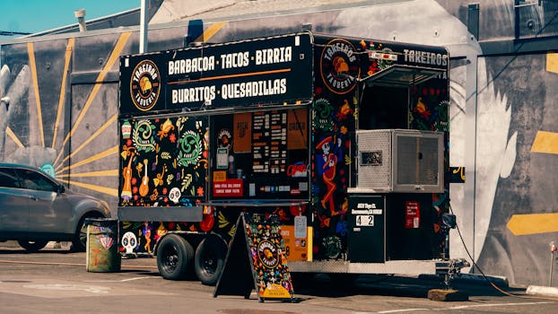 Vibrant Mexican food truck offering tacos and burritos in a lively urban environment.