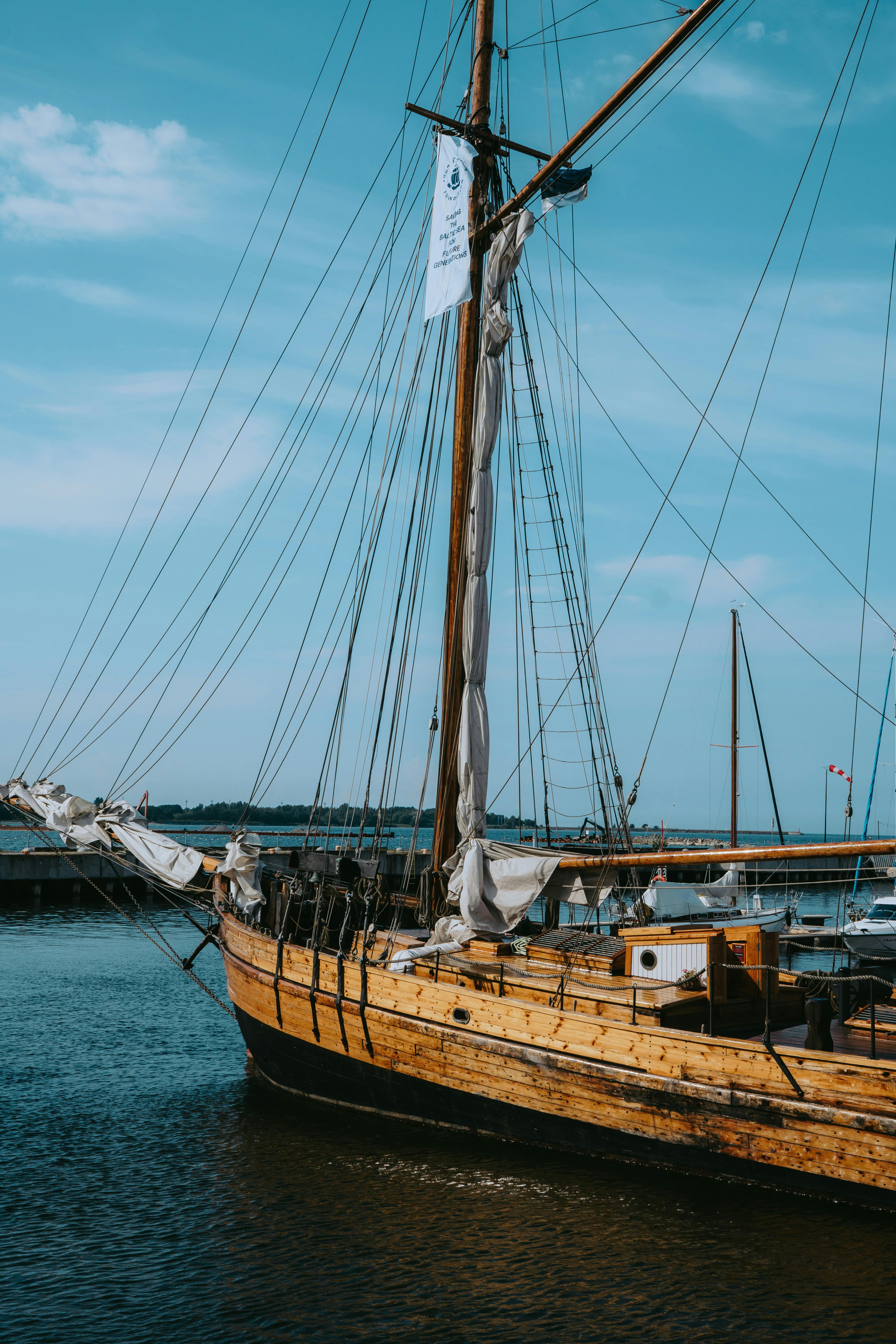 Wooden sailboat docked at Tallinn's Noblessner Marina under a clear blue sky.