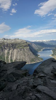 Stunning view of a fjord surrounded by rocky cliffs and blue skies.