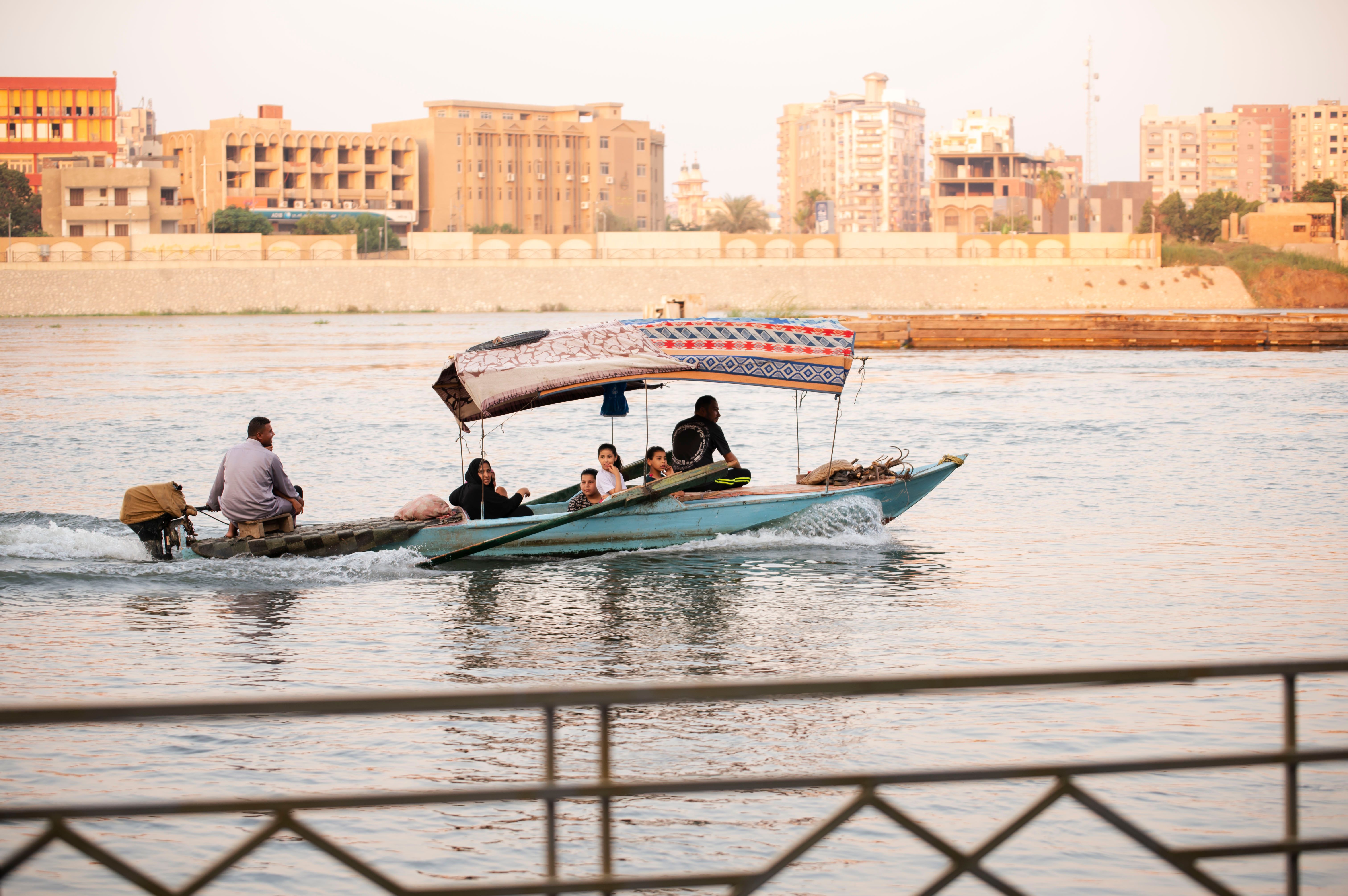 Scenic Boat Ride on River with Urban Backdrop · Free Stock Photo