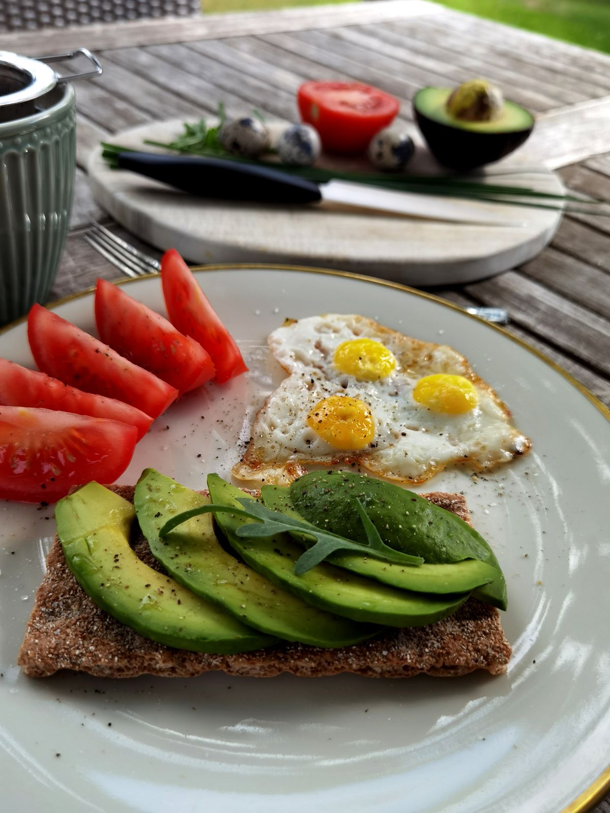Avocado toast with quail eggs and fresh tomatoes