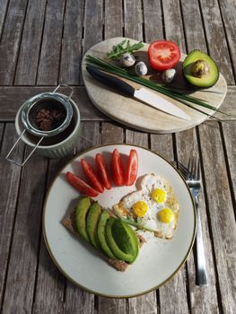 Top view of a healthy breakfast featuring avocado toast and quail eggs.
