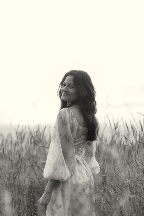 Free A serene black and white portrait of a woman in a meadow, exuding tranquility. Stock Photo