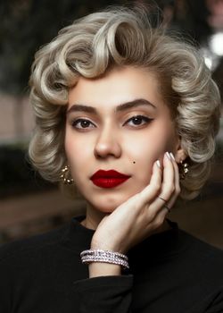 Close-up portrait of a woman with vintage hairstyle and bold makeup exuding elegance.