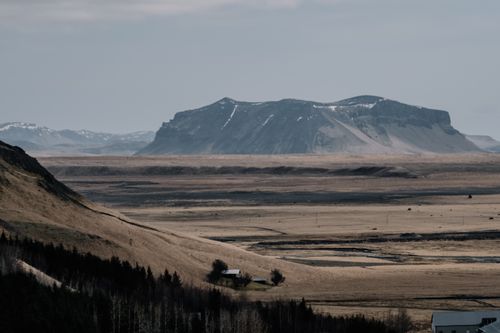 Free Captivating view of Iceland's rugged terrain with a distant mountain under a clear sky. Stock Photo