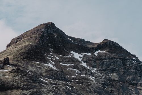 Free A stunning view of a rugged snow-capped mountain under a clear sky. Stock Photo