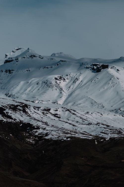 Free A stunning view of a snow-capped mountain under a clear sky, exuding a serene winter feel. Stock Photo