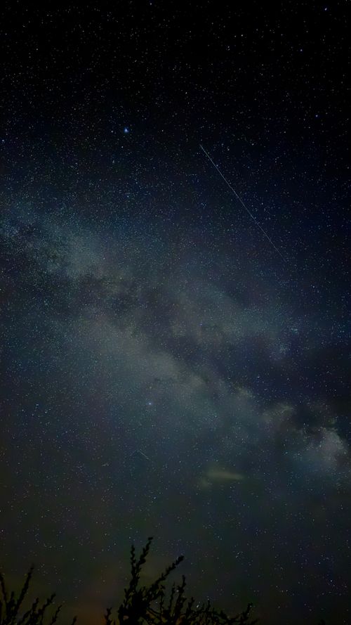 Free Breathtaking view of the Milky Way with a visible meteor streaking across the starry night sky. Stock Photo