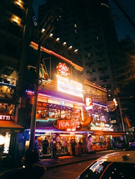 Colorful neon lights illuminate a retro diner scene at night.