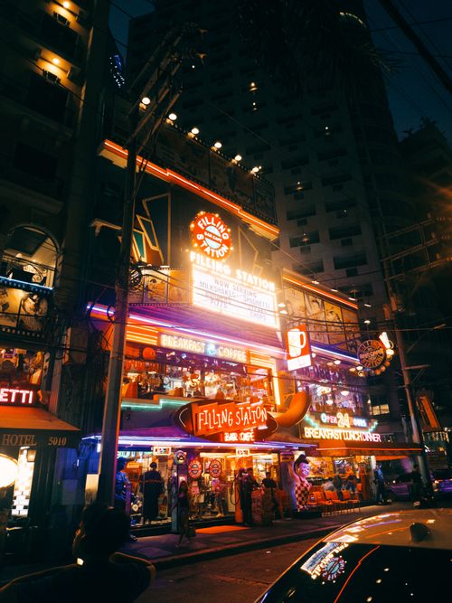Free Colorful neon lights illuminate a retro diner scene at night. Stock Photo