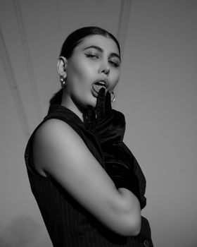 Elegant black and white portrait of a woman in gloves posing dramatically.