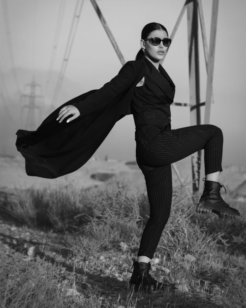 Free Confident woman in a chic suit poses dramatically outdoors in monochrome. Stock Photo