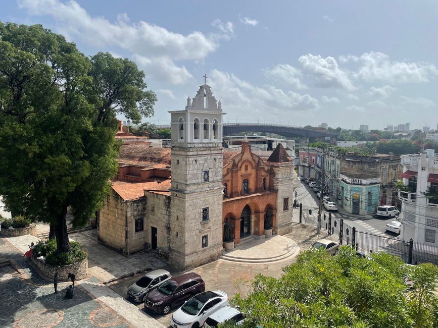 Aerial view of a historic colonial church in Santo Domingo under a bright day.