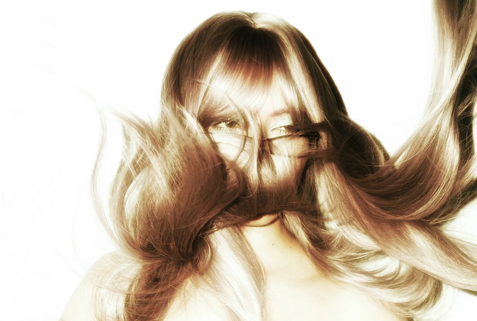 Artistic portrait capturing flowing hair with face obscured, creating a dynamic and mysterious visual.