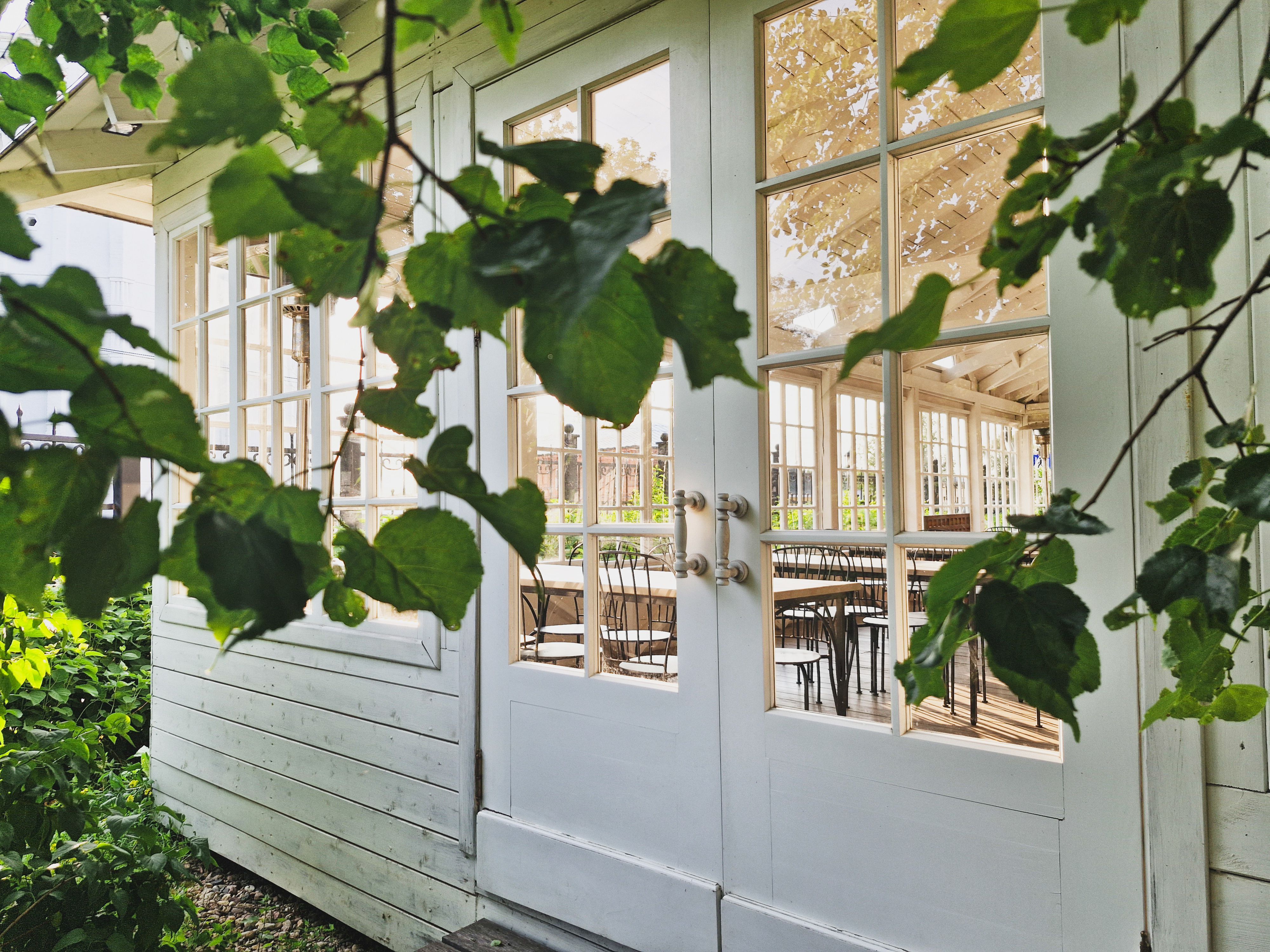 Portes-fenêtres d'un studio de jardin ouvertes sur la verdure