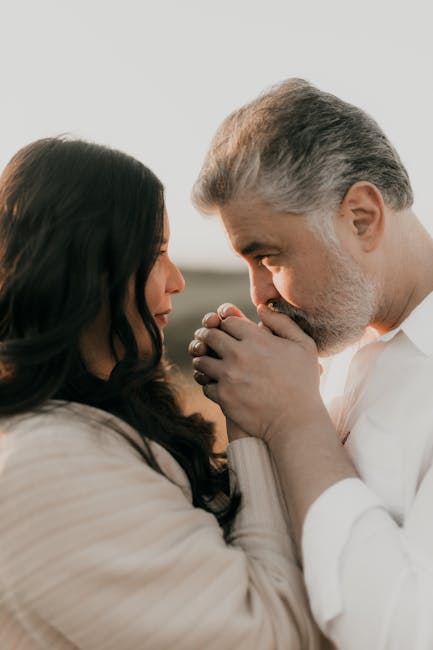 A touching scene of a couple sharing an intimate moment outdoors during sunset.