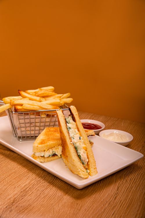 Free Mouthwatering club sandwich with crispy fries and dipping sauces on a white plate. Stock Photo