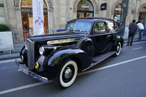 Free Elegant vintage car showcased at an outdoor exhibition in a city setting, capturing the charm of classic automobiles. Stock Photo