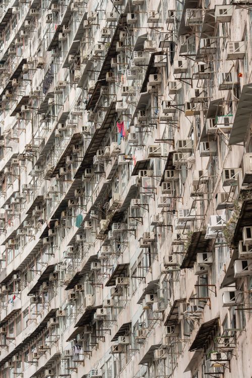 Free Close-up view of a building facade filled with air conditioners and windows, reflecting urban density. Stock Photo