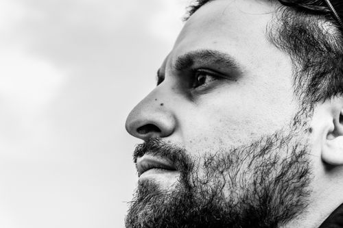 Free Black and white close-up portrait of a contemplative bearded man looking into the distance. Stock Photo