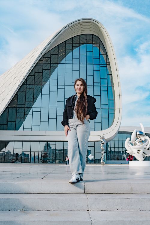 Free Stylish woman poses confidently in front of the Heydar Aliyev Center in Baku. Stock Photo