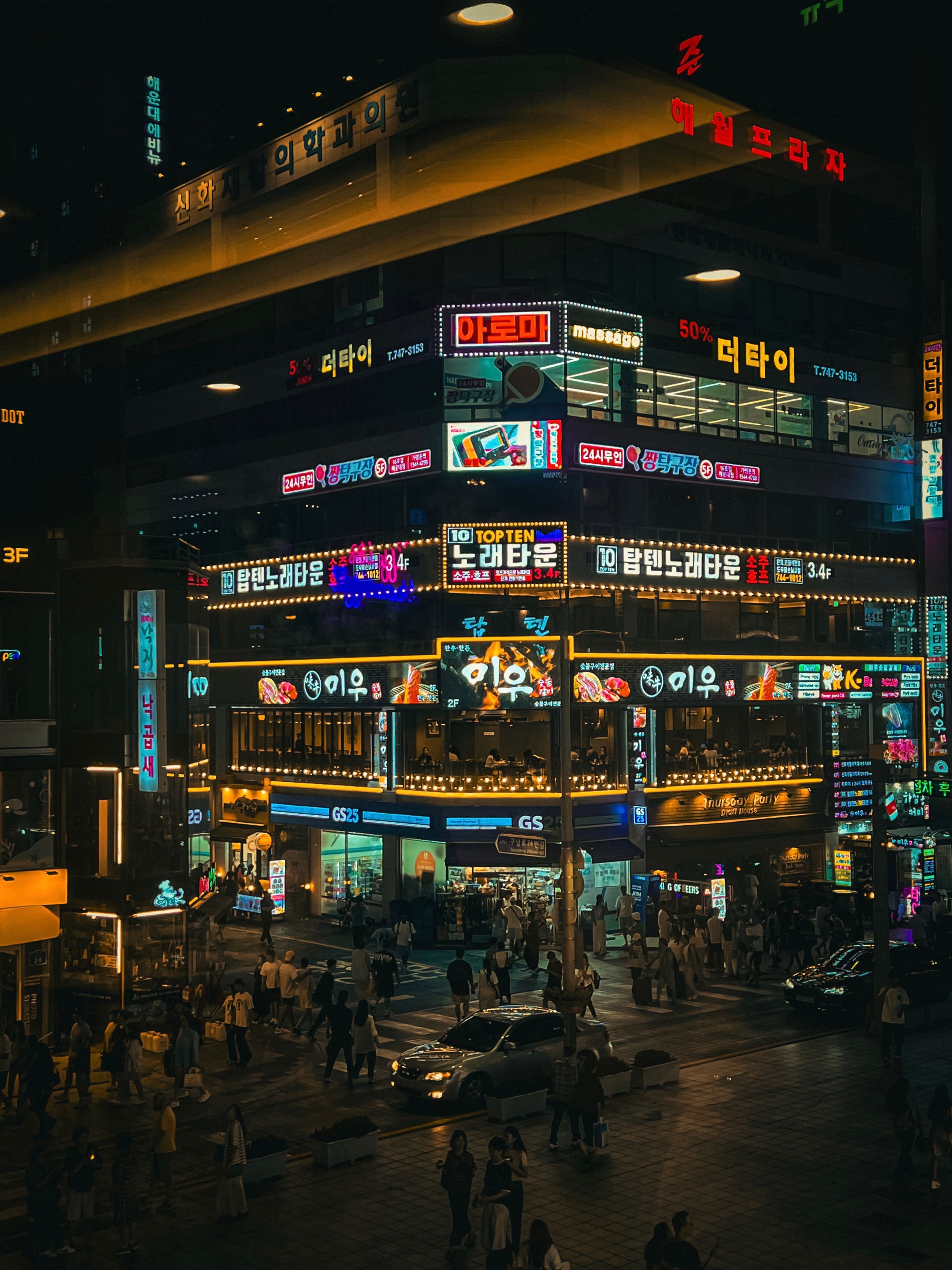 oleh oleh korea selatan di kawasan Myeongdong Seoul saat malam dengan lampu toko dan wisatawan