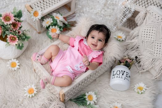 Charming baby in a cozy setting with daisies and floral decor, exuding warmth and joy.