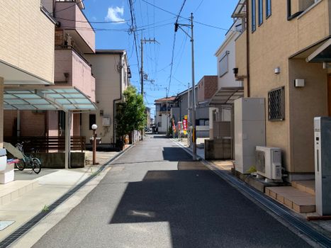 A peaceful residential street with modern homes under a clear blue sky.