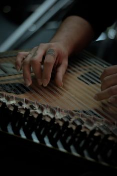 Detail photo of hands playing a string instrument capturing intricate finger movements.