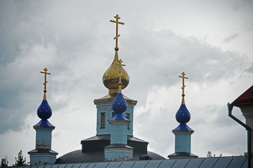 Free Golden and blue domes of an Orthodox church with crosses under a cloudy sky. Stock Photo