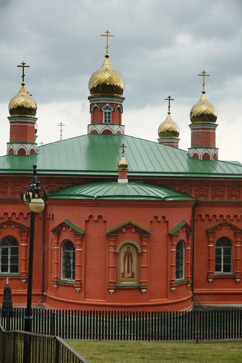 Free A vibrant Russian Orthodox Church with golden domes and ornate details under a cloudy sky. Stock Photo