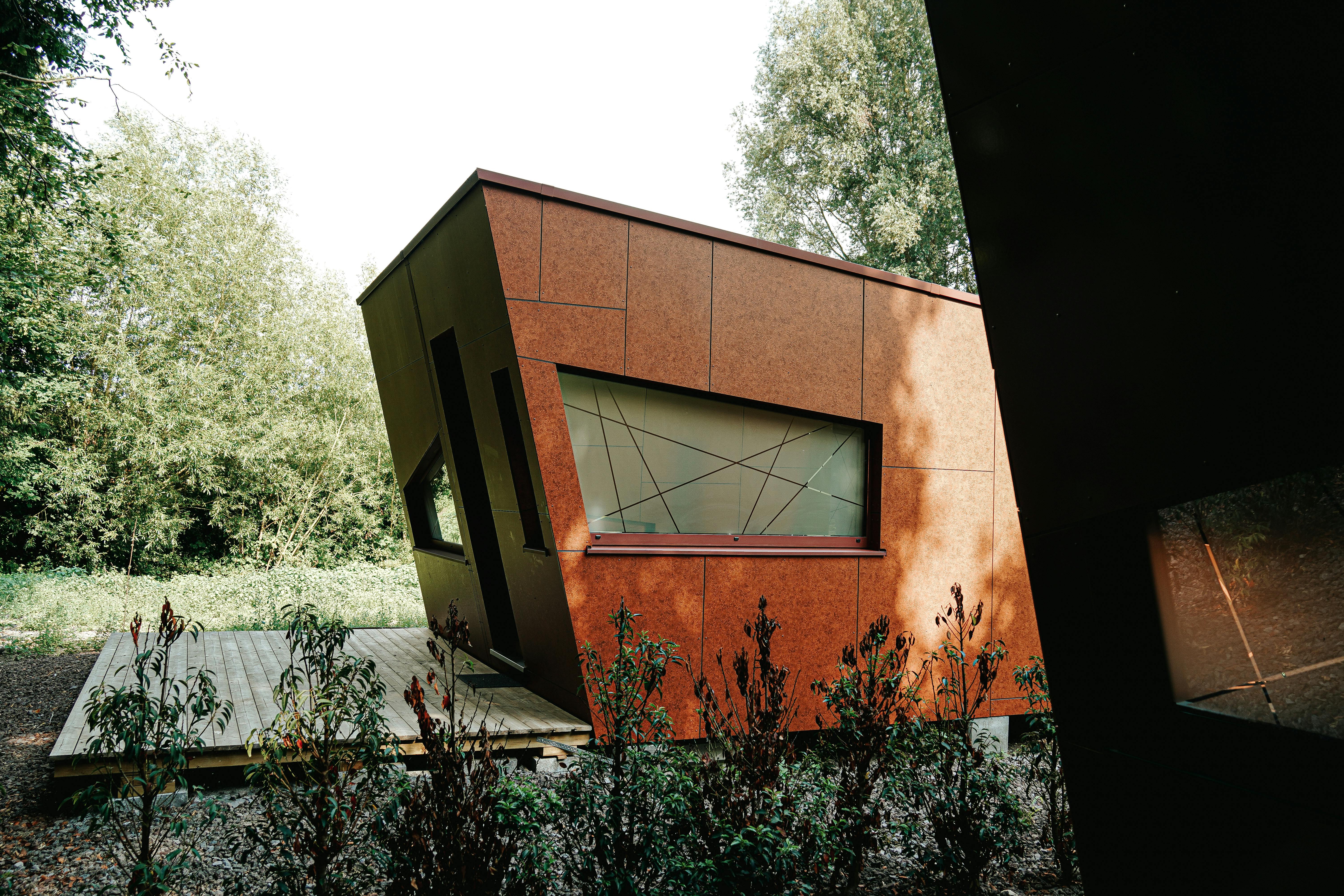 Contemporary angular architecture nestled in a green forest setting, showcasing unique design.