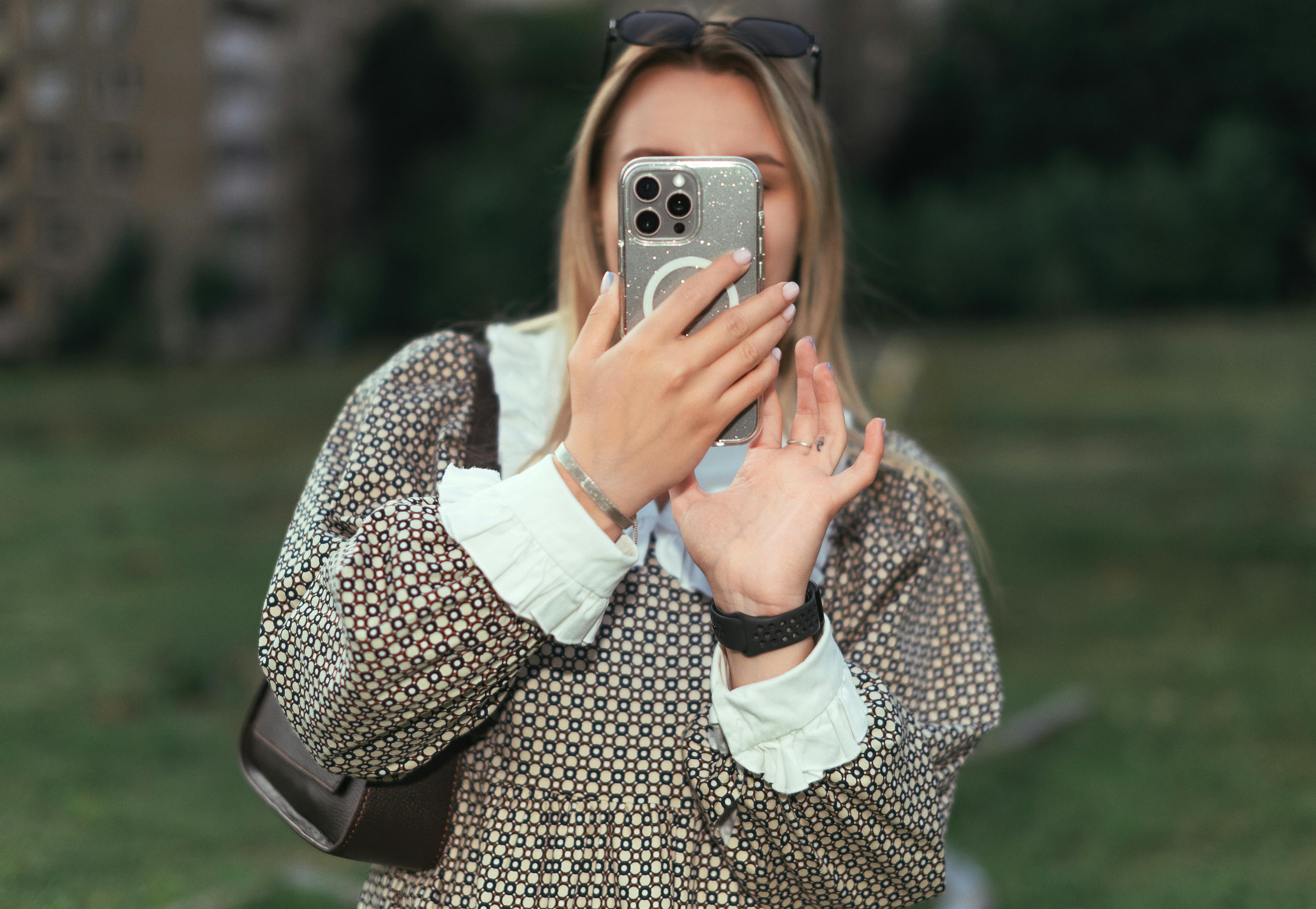 bezplatná Žena si za slunečného dne pořizuje selfie venku v Minsku v Bělorusku. Na hlavě má sluneční brýle. Základová fotografie