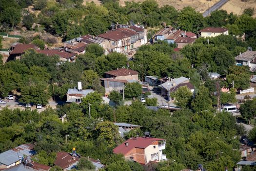 Scenic aerial shot of a lush neighborhood in Elâzığ, Turkey, surrounded by greenery and rustic architecture.