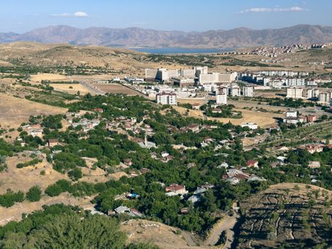 Aerial shot of Elâzığ city showcasing residential areas, hospital, and surrounding mountains.