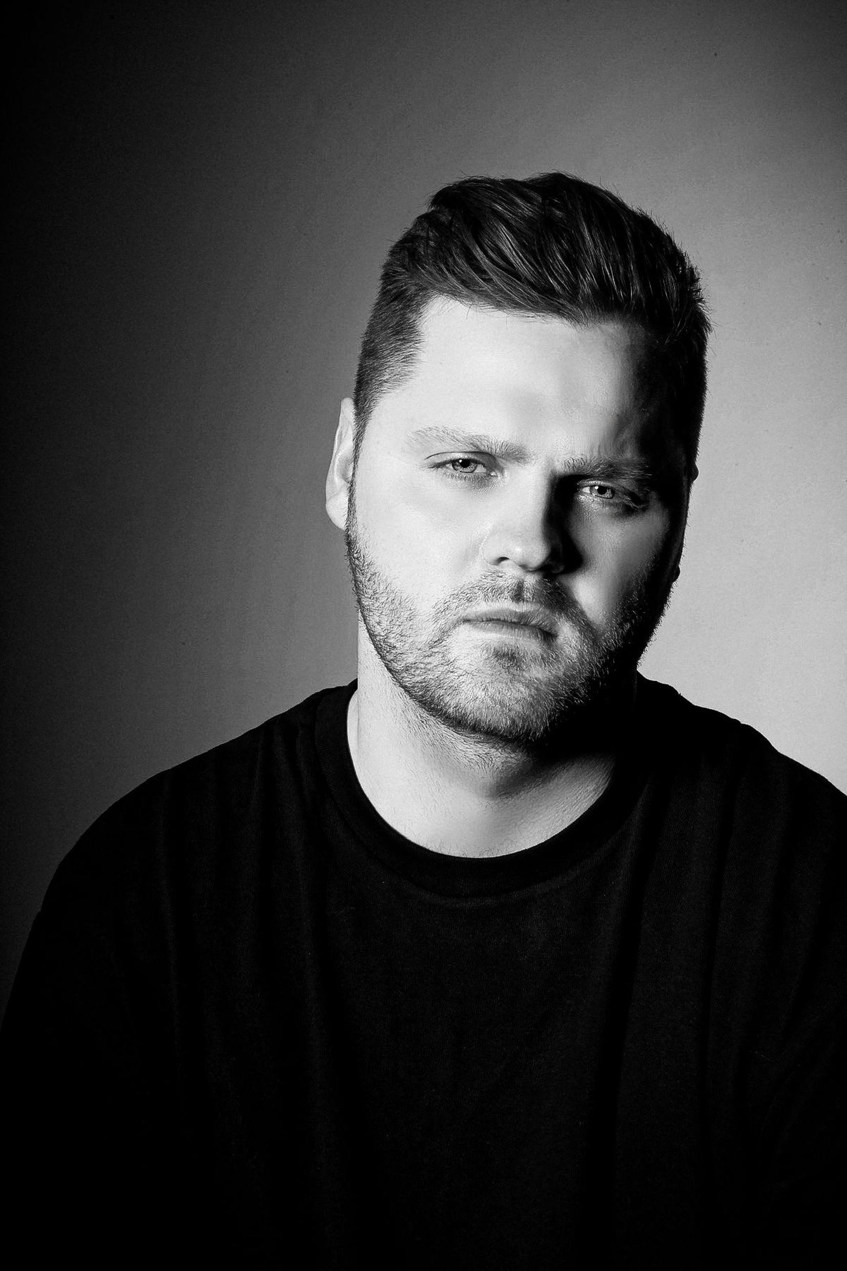 Bezpłatne Czarno-biały artystyczny portret mężczyzny o ponurym wyrazie twarzy. Zdjęcie z galerii