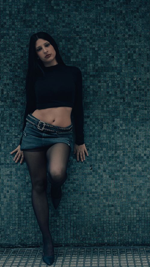 Free Fashionable young woman posing against a tiled wall in Buenos Aires, Argentina. Stock Photo