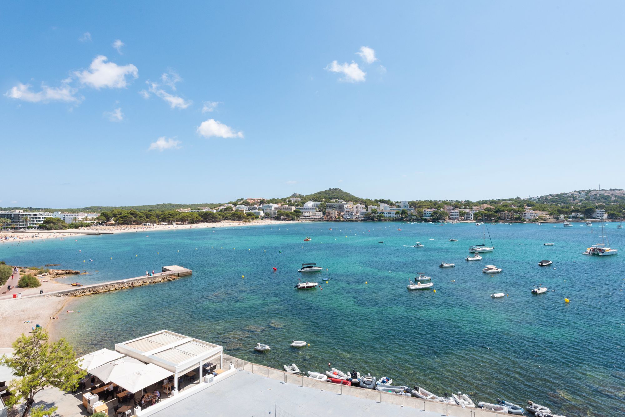 Picturesque Santa Ponsa bay view featuring boats, clear turquoise waters, and a sandy beach.