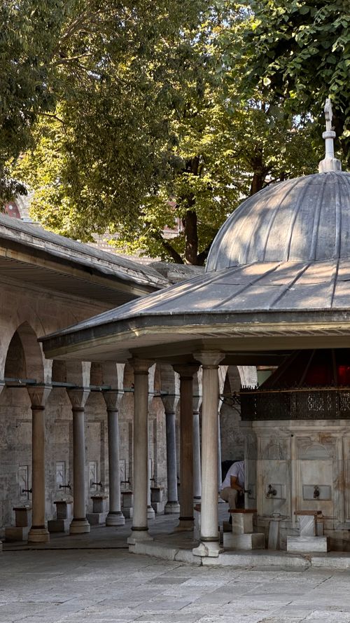 Free Peaceful Ottoman-style courtyard with pillars and sunlight. Ideal for historical architecture enthusiasts. Stock Photo