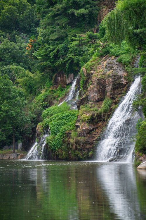 Free Picturesque waterfall cascading over rocks in Seoul, South Korea's verdant landscape. Stock Photo