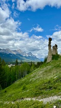 Dramatic hoodoos stand against the stunning Canadian Rockies under a vibrant sky.