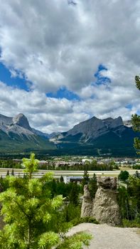 Breathtaking Rocky Mountain landscape with lush greenery and cloudy sky.