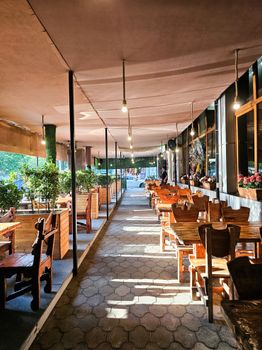 Warm and inviting outdoor café seating with wooden furniture and natural light at sunset.