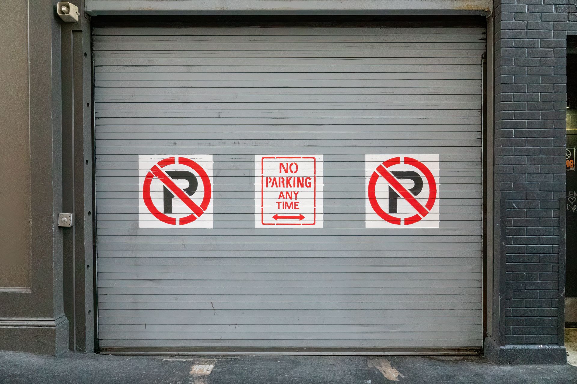 Steel garage door with no parking signs in San Francisco, outdoor urban scene.