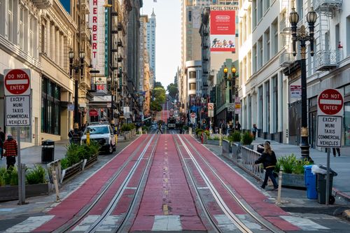 Free Vibrant street view of San Francisco with people, shops, and iconic signs. Stock Photo