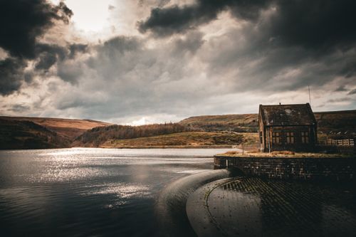 Free Dramatic view of Marsden Reservoir under stormy skies with old stone building. Stock Photo