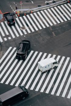 Aerial shot capturing a bustling Tokyo street intersection with vehicles and pedestrian crossings.